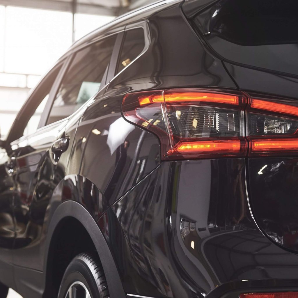 die-hinteren-scheinwerfer-eines-schwarzen-luxusautos-scaled