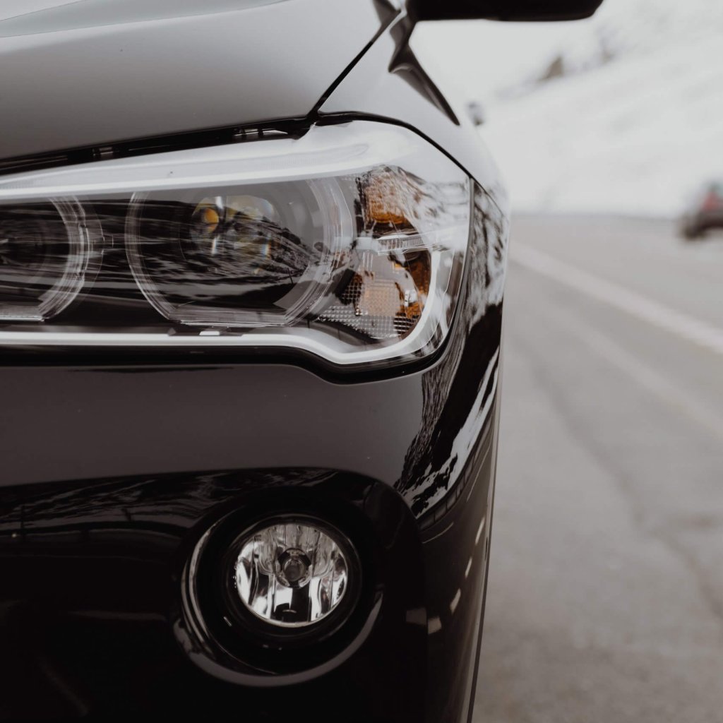 vertikale-aufnahme-des-linken-teils-eines-schwarzen-teuren-autos-auf-der-strasse-perfekte-tapete-hintergrund-scaled